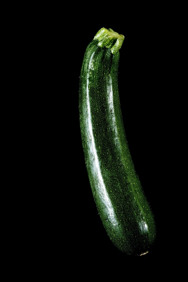 Зеленый кабачок на черном фоне