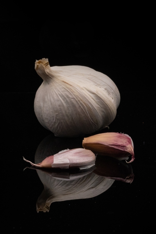 Головка чеснока на черном фоне