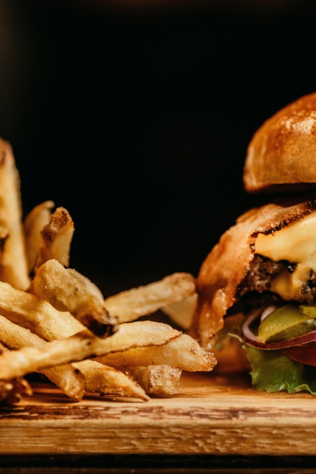 Сочный гамбургер на столе с картофелем фри