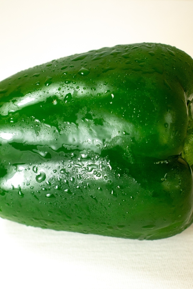 Крупный зеленый перец на белом фоне