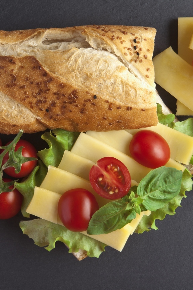 Батон с сыром и помидорами на сером фоне