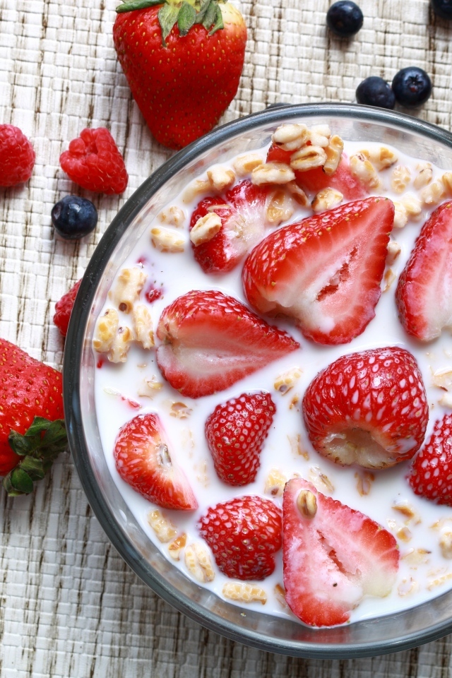 Овсянка с молоком в тарелке с ягодами малины