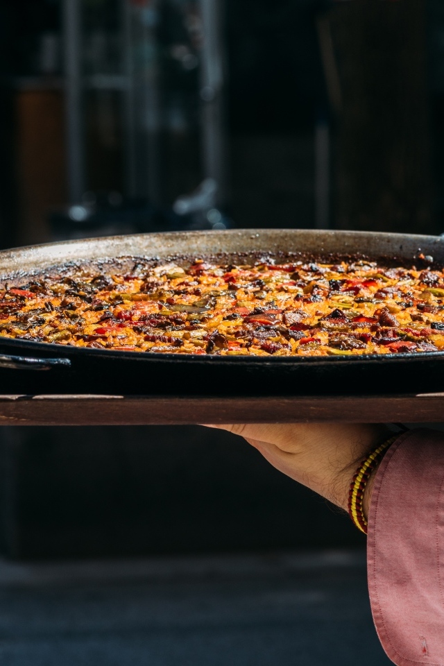 Блюдо паэлья в руках 