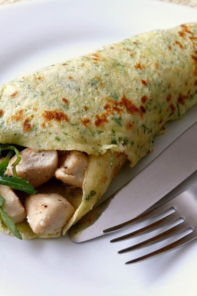 Блин с жареной курицей и рукколой на тарелке 