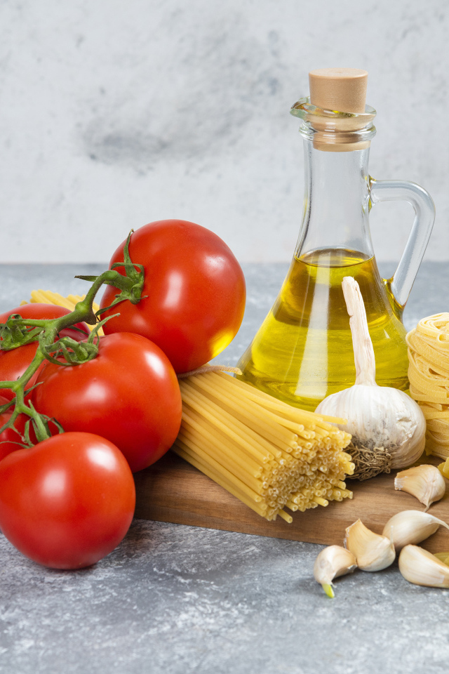 Паста, помидоры и масло на столе