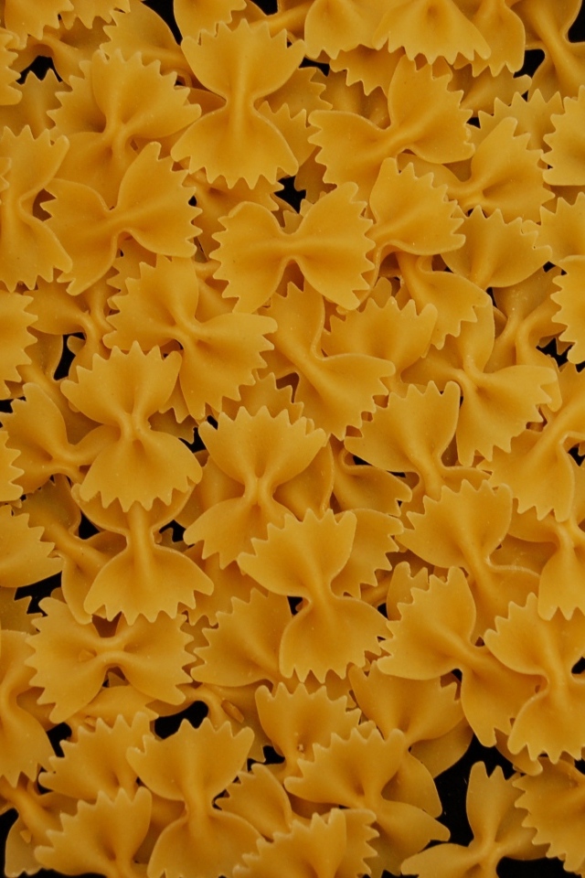 Макароны в форме бантиков на черном фоне