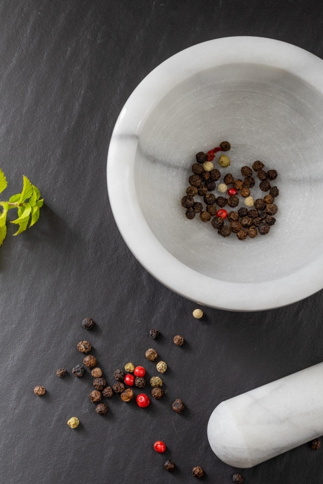 Перец горошком в ступе на сером столе