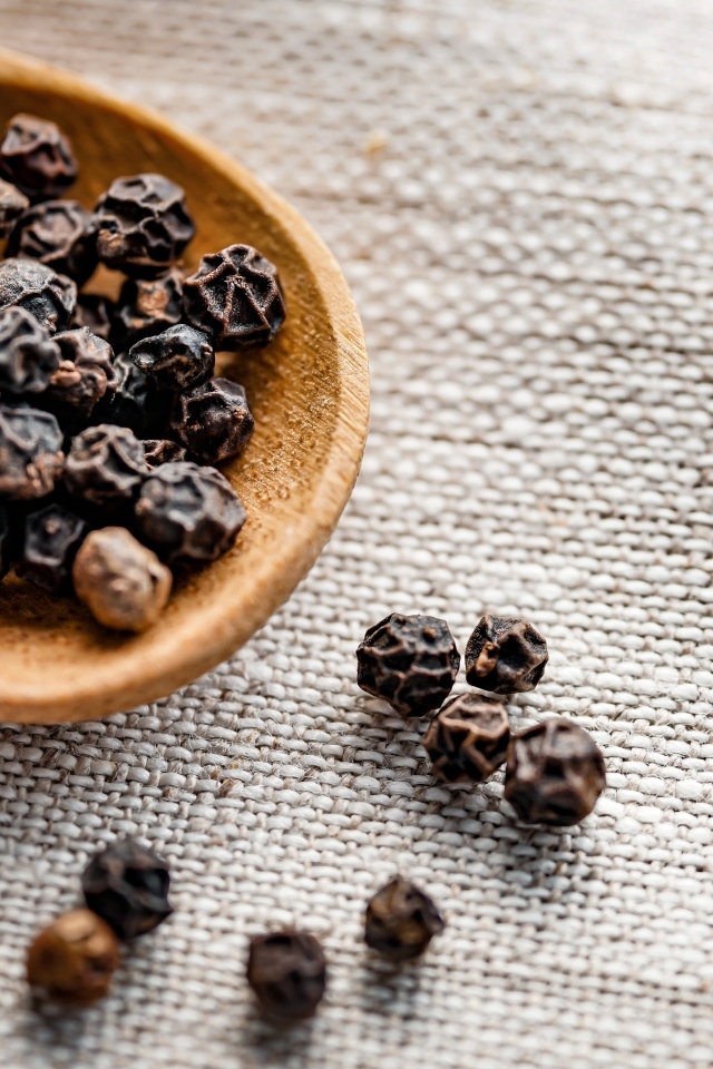 Перец горошком на деревянной ложке