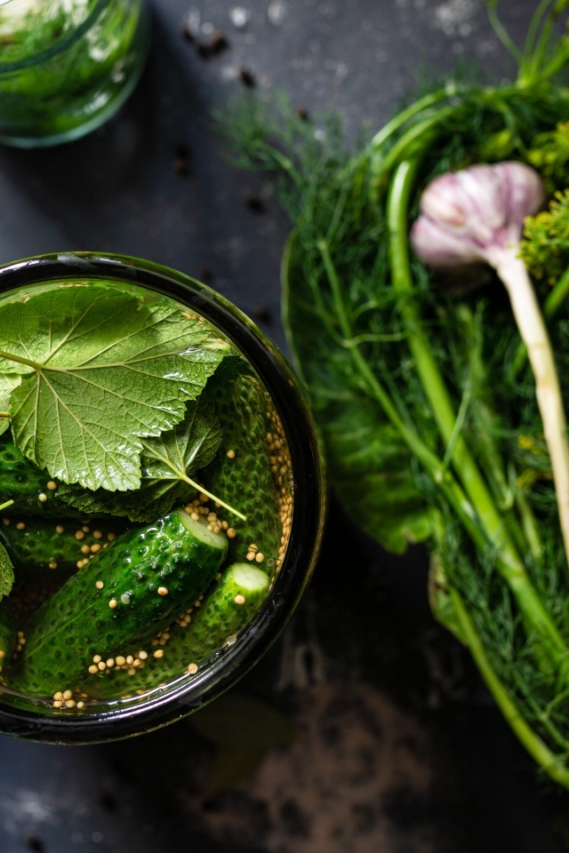 Маринованные огурцы с зеленью и чесноком на столе