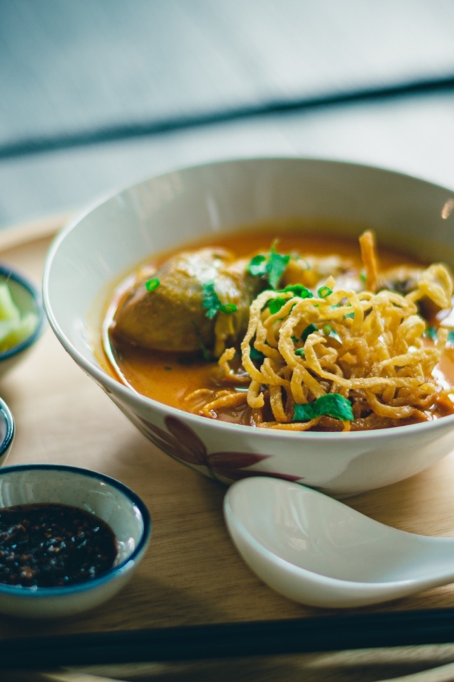 Суп рамен на подносе с луком и соусом