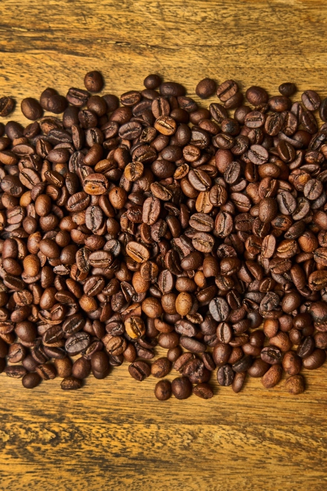 Жареные кофейные зерна на деревянном столе