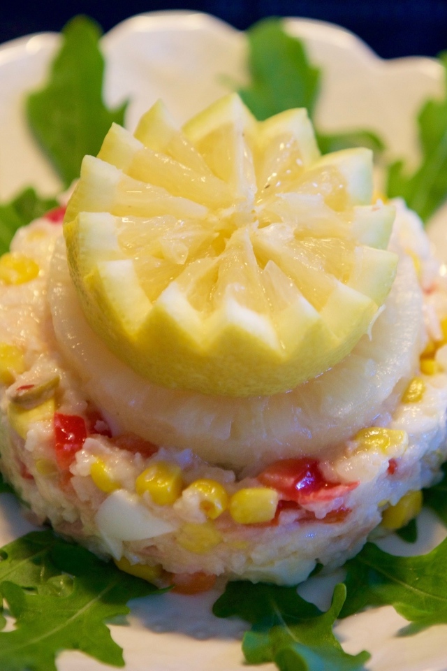 Салат на тарелке с лимоном и рукколой