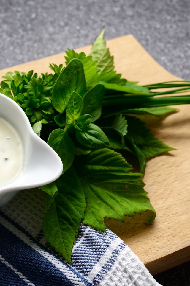 Соус с зеленью на деревянной доске 