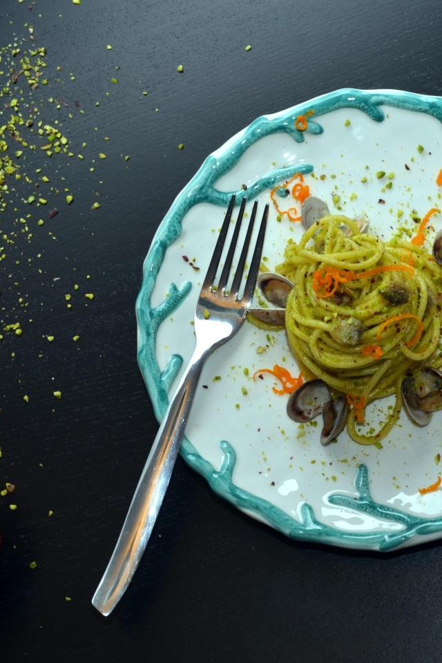 Спагетти с морепродуктами на столе с апельсинами