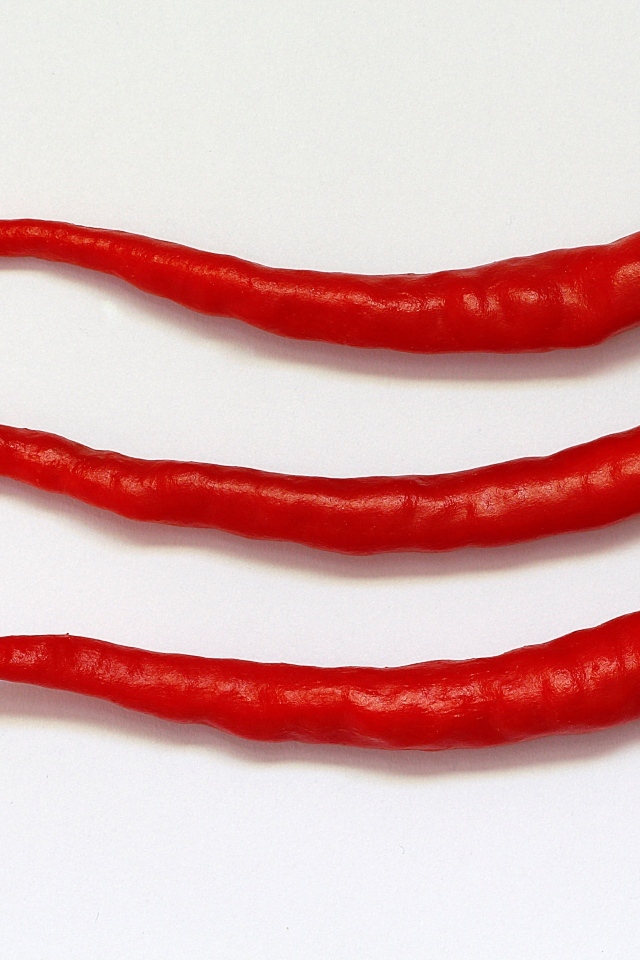 Три перца чили на сером фоне