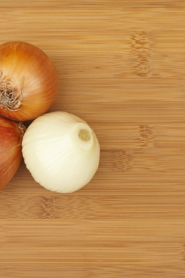 Три луковицы на деревянном столе