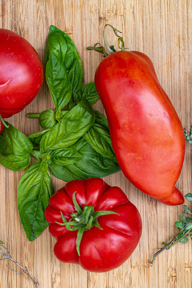 Помидоры  на разделочной доске с базиликом