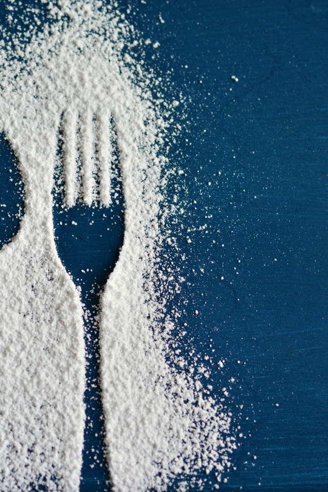 Следы от вилки и ложки сахарной пудрой на столе