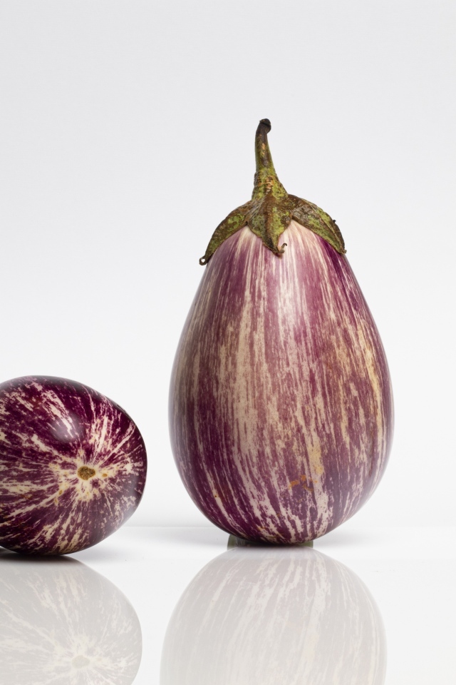 Два баклажана на сером фоне