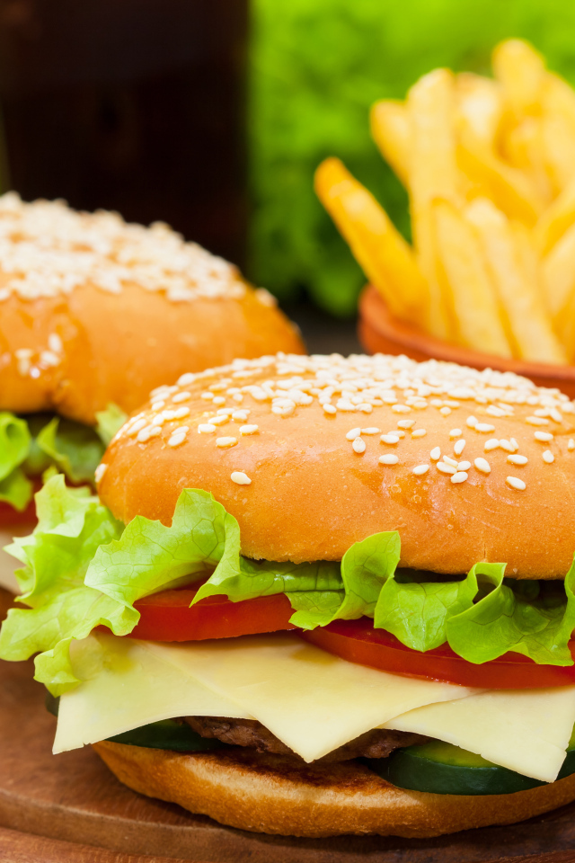 Два больших гамбургера на столе с картофелем фри