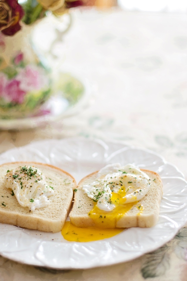 Два куска хлеба с яйцом на тарелке на завтрак