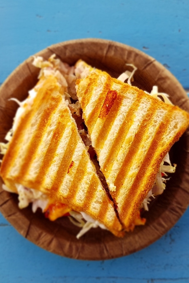 Два сэндвича на тарелке на голубом столе