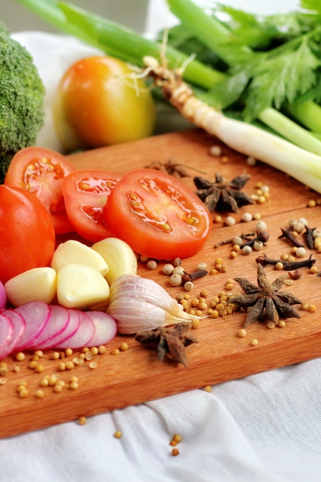 Овощи с зеленью на разделочной доске 