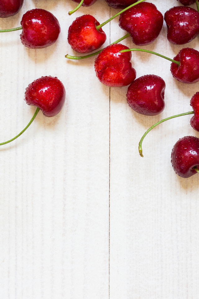 Аппетитные свежие красные ягоды черешни на белом столе