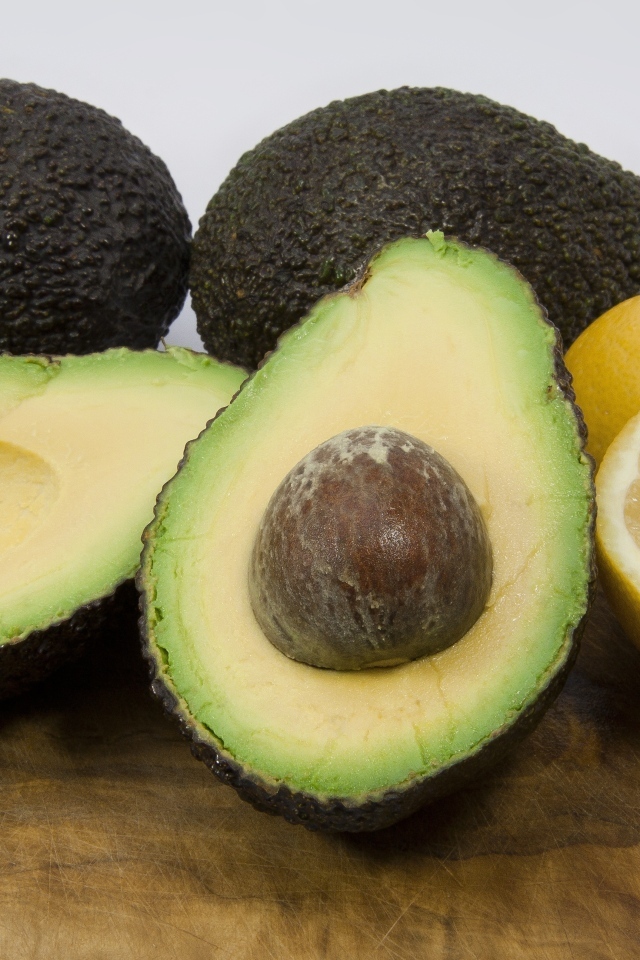 Авокадо на столе с половинками лимона