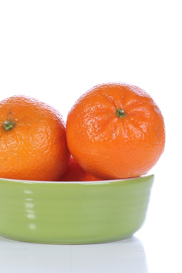 Красивые мандарины в миске на белом фоне