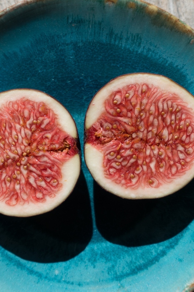 Половинки инжира на голубой тарелке