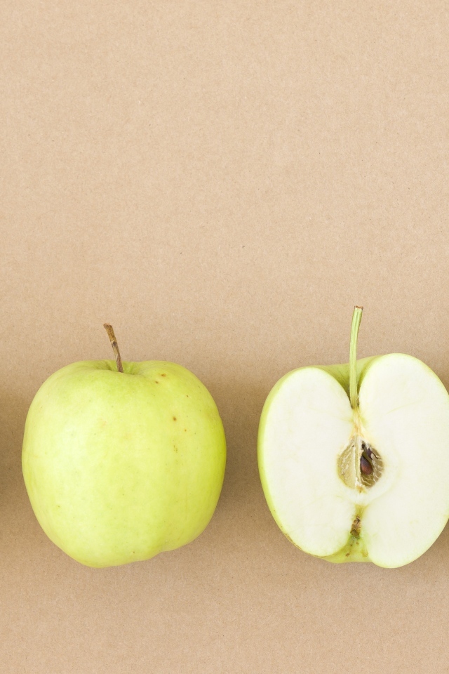 Четыре зеленых яблока на бежевом фоне 