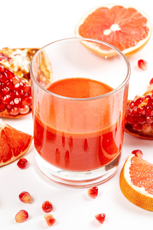 Грейпфрут и гранат на столе с соком