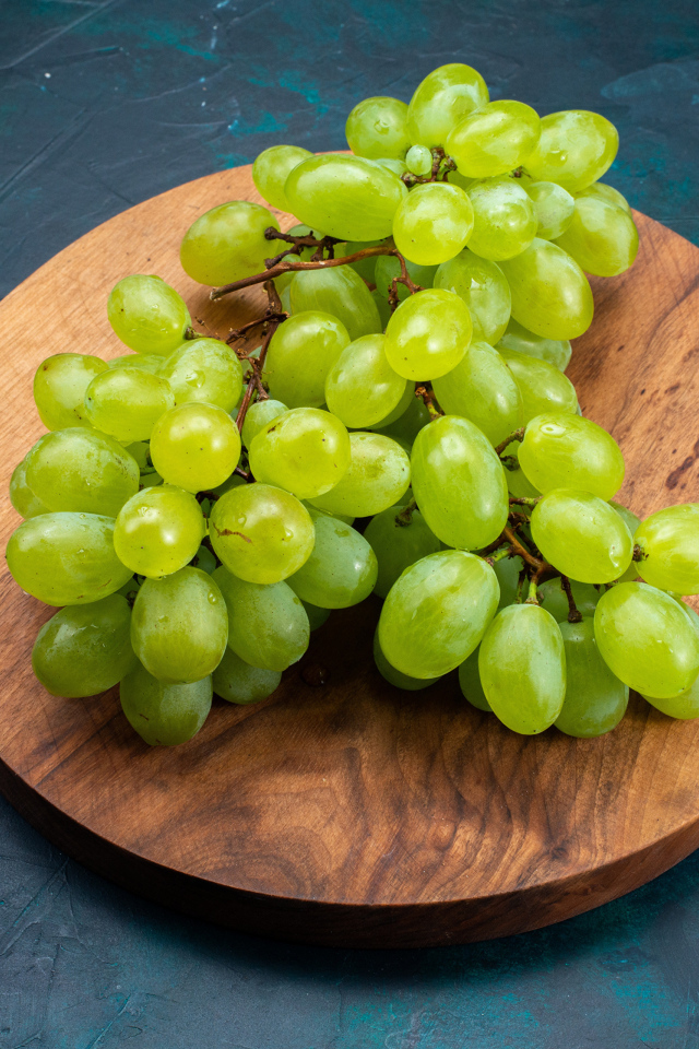 Зеленый виноград на деревянной доске