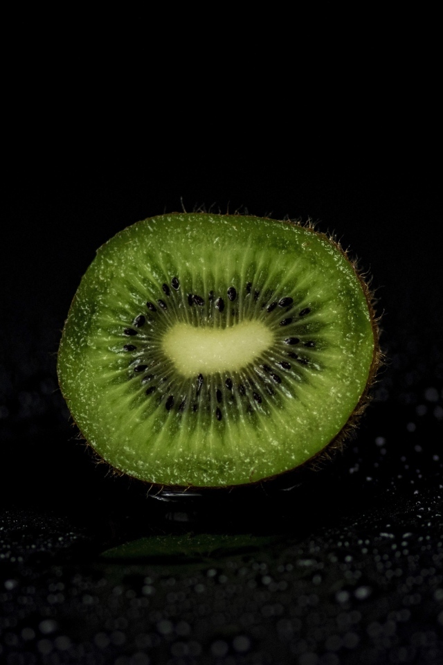 Половина киви на черном фоне в воде