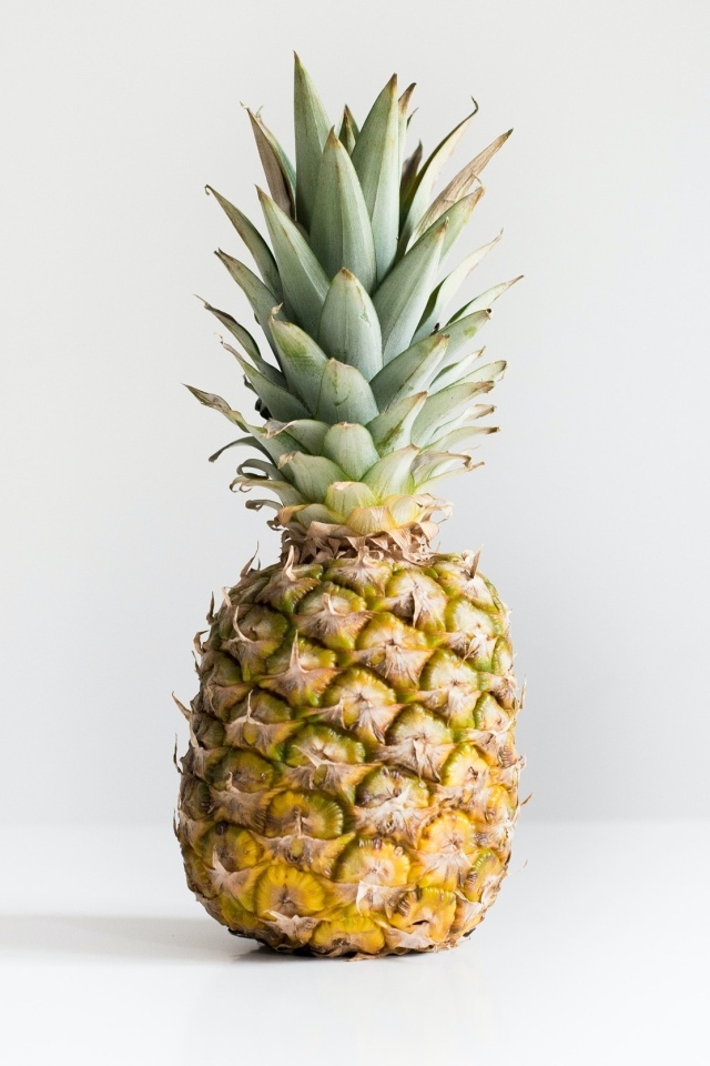 Большой ананас на сером фоне