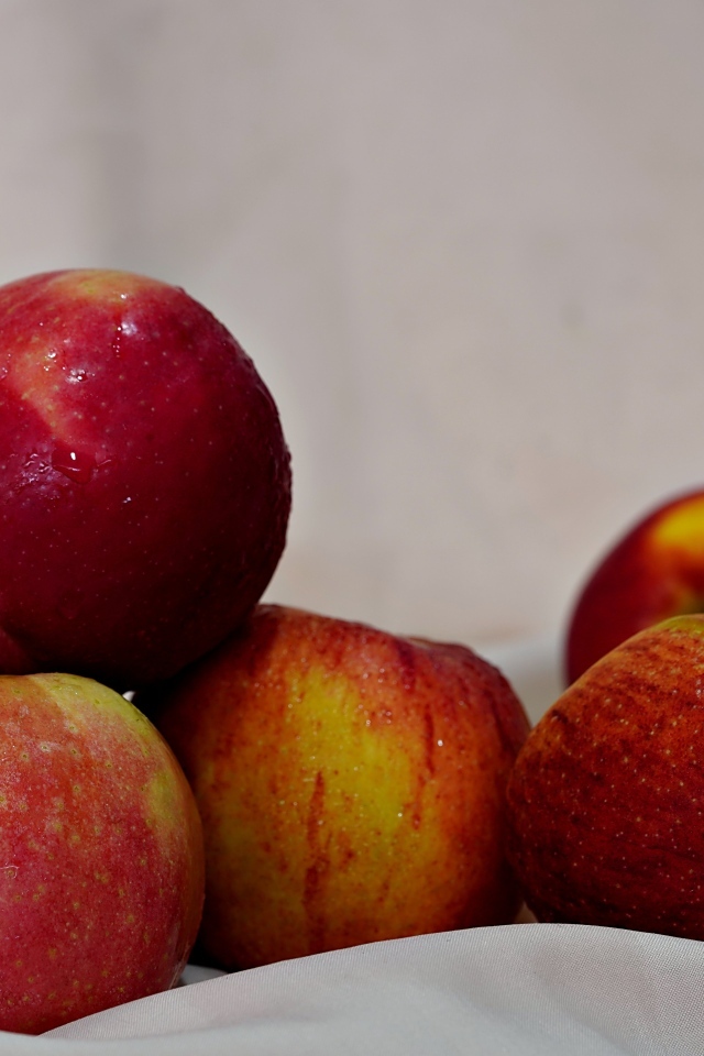 Много красных яблок с белой тканью 