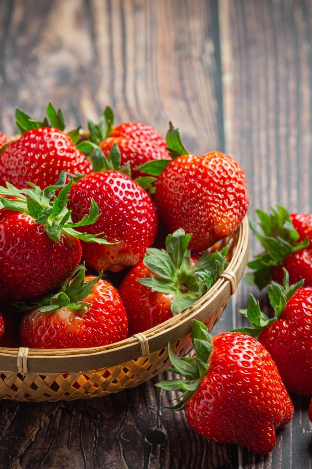 Много спелой красной клубники в деревянной посуде 