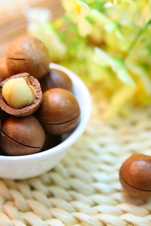 Орехи макадамия на столе с цветами