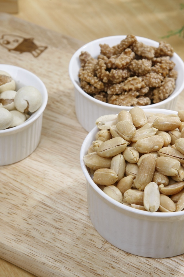 Орехи в белой посуде на доске