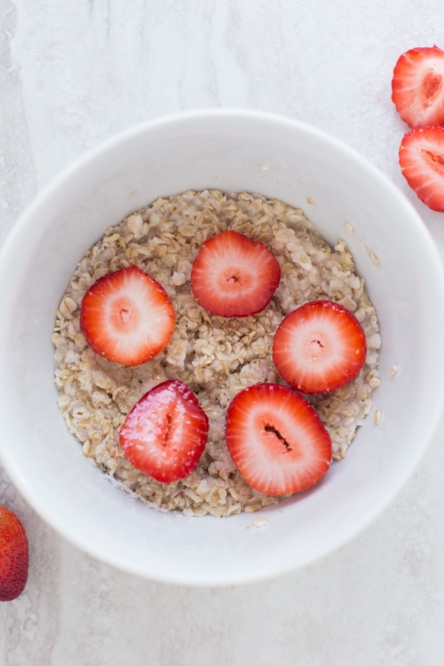 Овсяная каша с клубникой в белой тарелке 