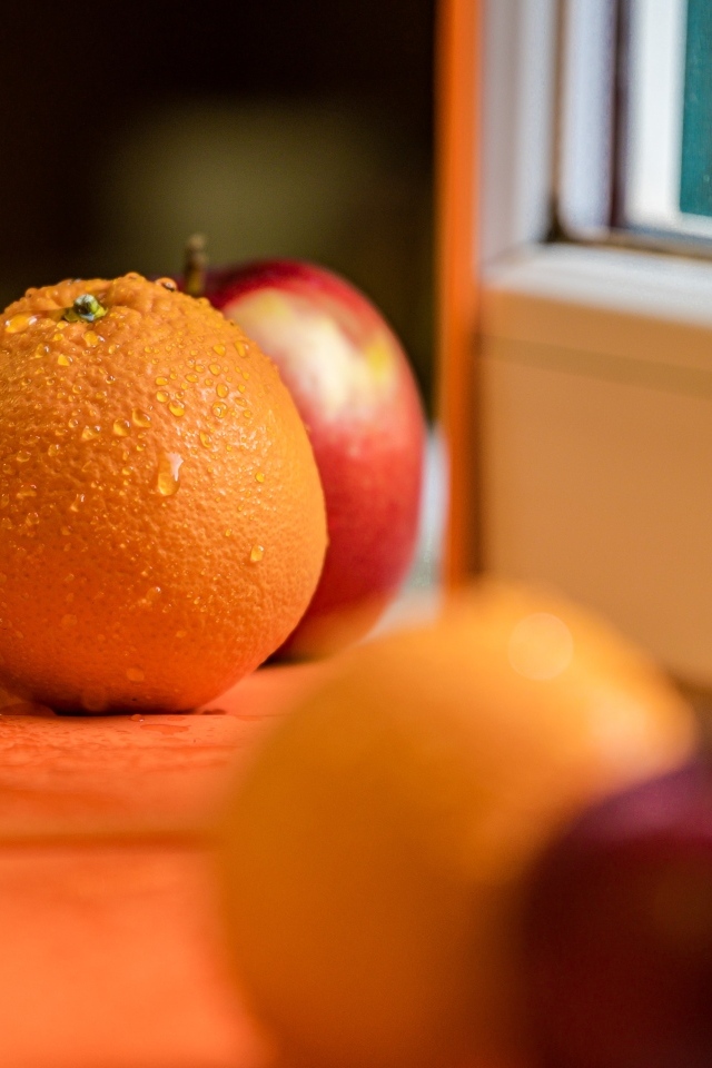 Апельсин и яблоко отражаются в зеркале