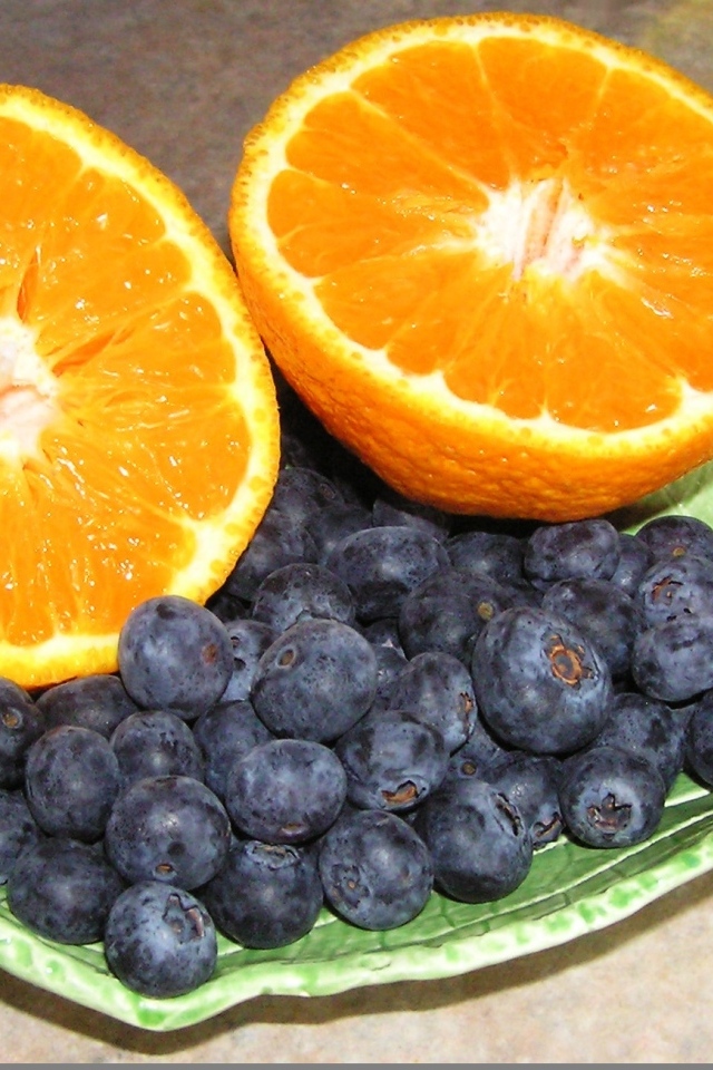 Половинки апельсина с ягодами черники на столе