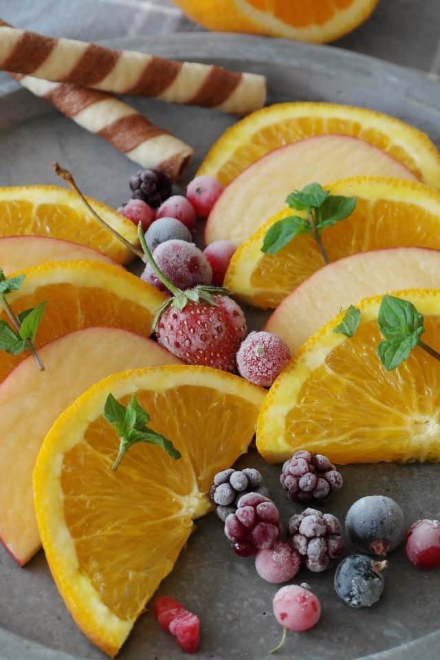 Кусочки апельсина с яблоком и замороженными ягодами