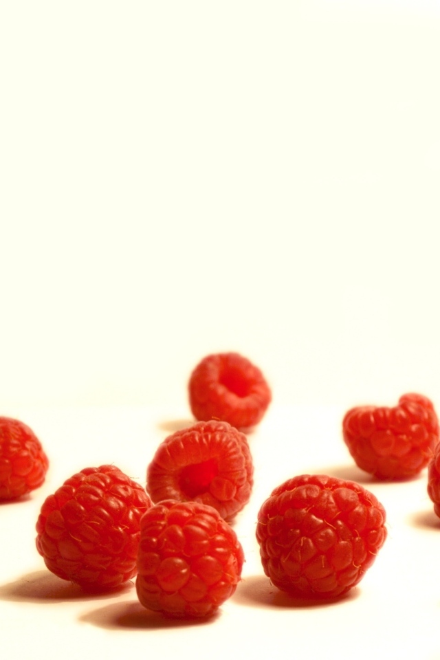 Красные ягоды малины на белом фоне крупным планом