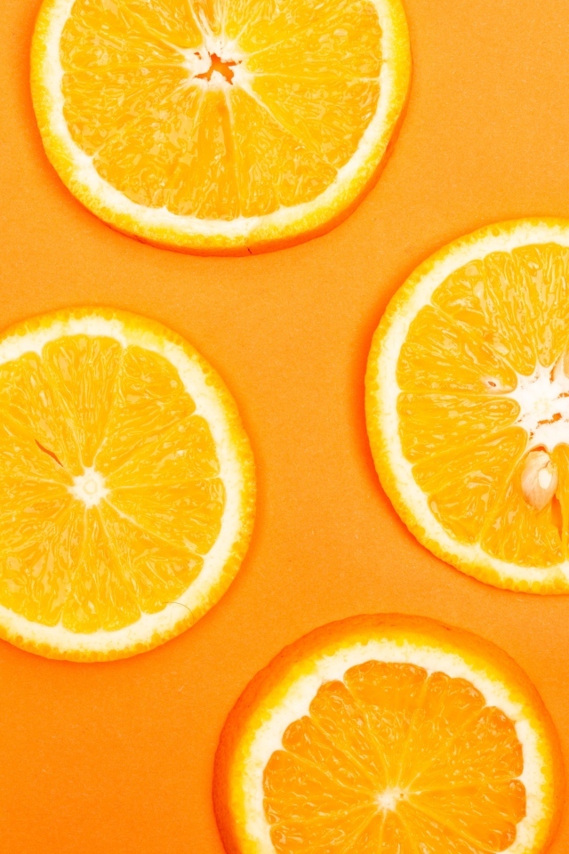 Спелый апельсин на оранжевом фоне