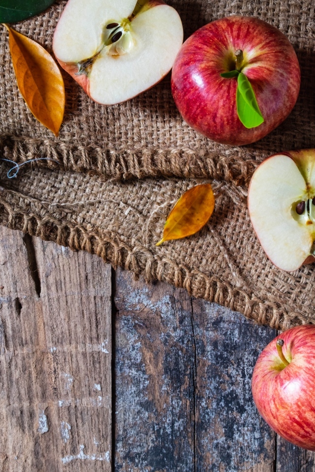 Спелые красные яблоки на столе с мешком