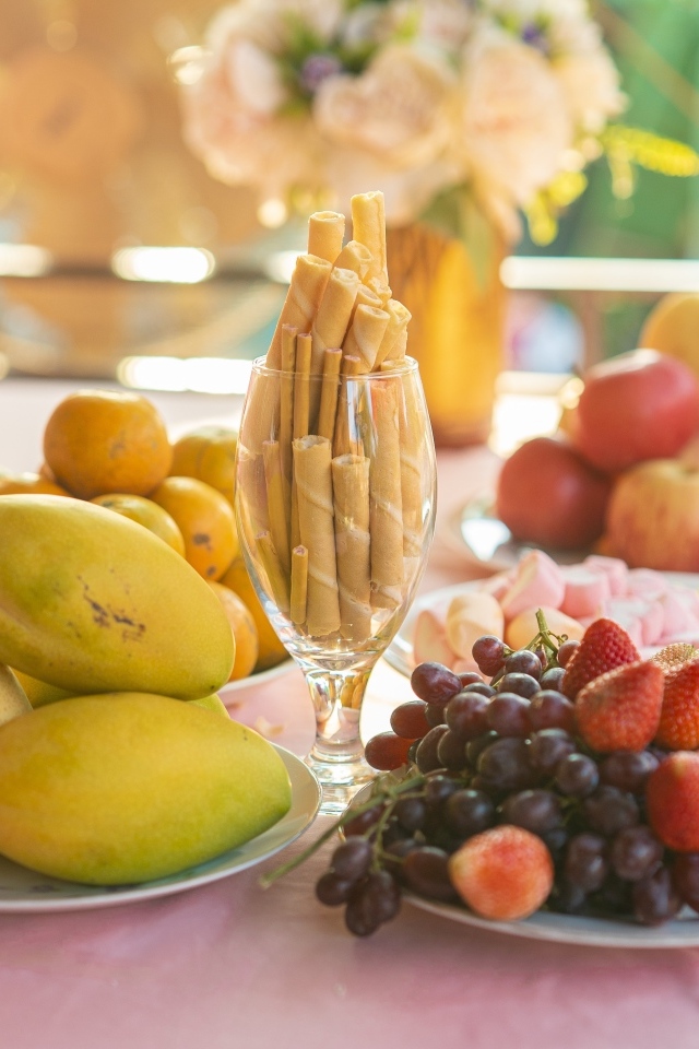 Спелые сладкие фрукты и ягоды на столе с трубочками