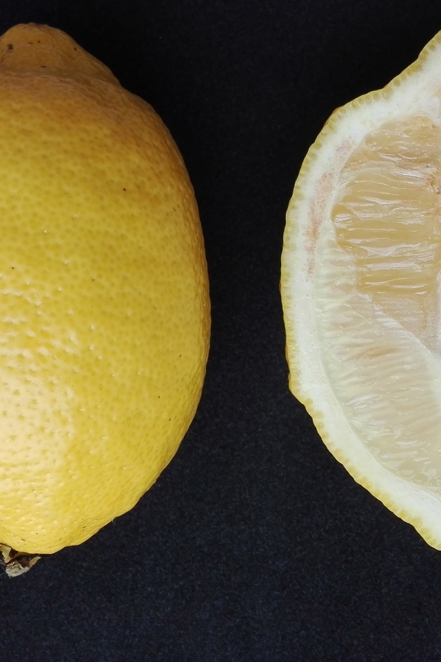 Разрезанный лимон на черном столе