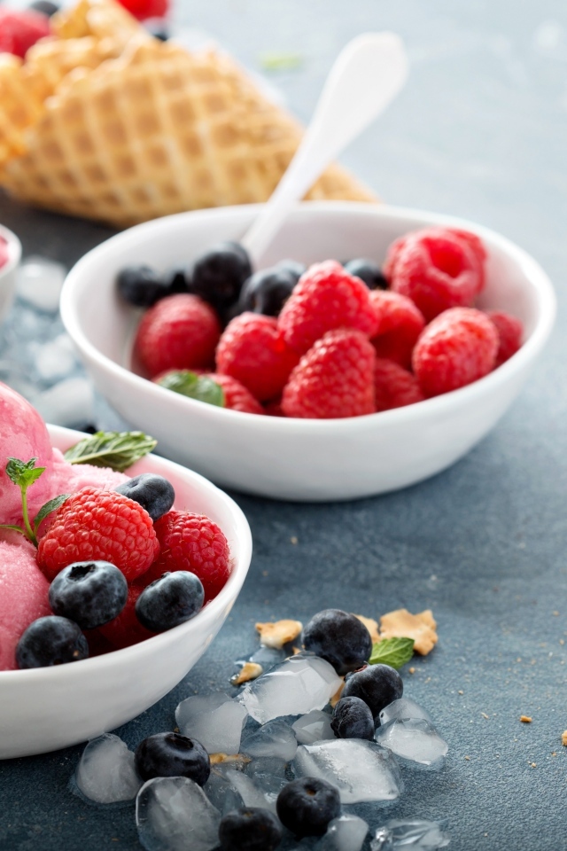 Сладкие ягоды с шариками мороженого на столе